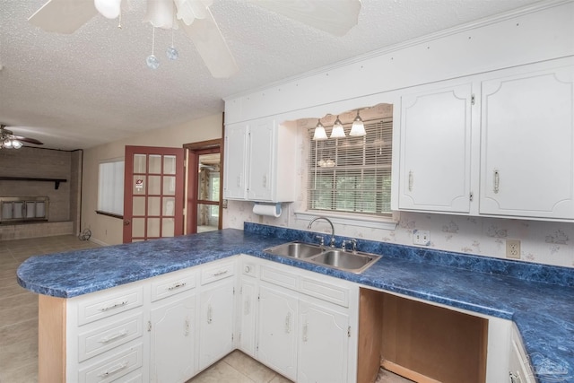 kitchen with sink, white cabinetry, a textured ceiling, kitchen peninsula, and ceiling fan