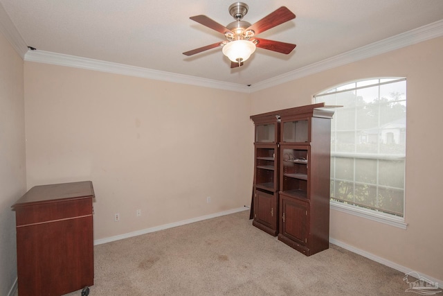 interior space with ceiling fan, light colored carpet, and crown molding