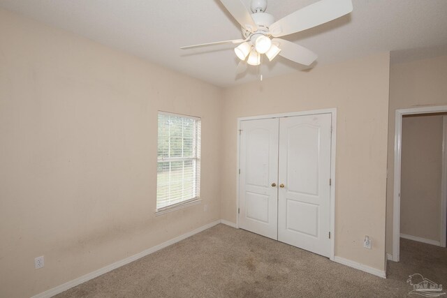 carpeted spare room featuring ceiling fan