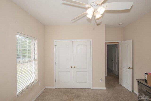 bedroom with a closet, ceiling fan, and light carpet