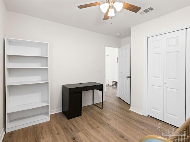 interior space with light wood-type flooring, a closet, and ceiling fan