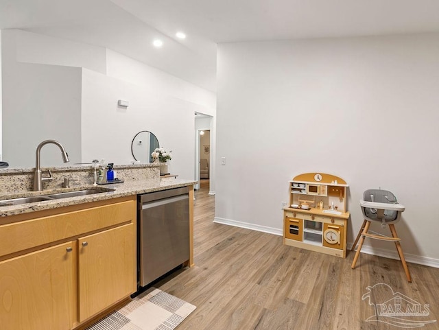 kitchen with sink, light hardwood / wood-style flooring, dishwasher, and light stone counters