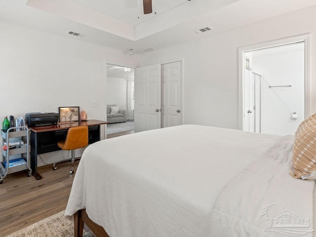 bedroom featuring a closet, ceiling fan, a raised ceiling, and hardwood / wood-style flooring