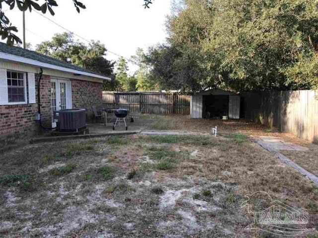 view of yard featuring a patio, a storage unit, and central AC