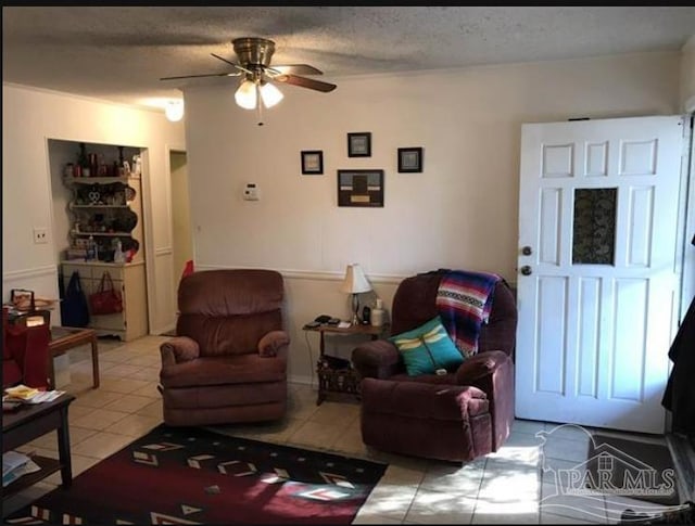 tiled living room featuring a textured ceiling and ceiling fan