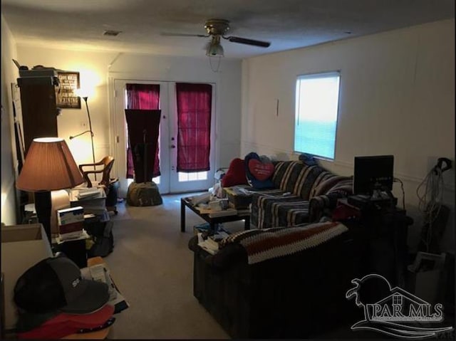 carpeted living room with french doors and ceiling fan