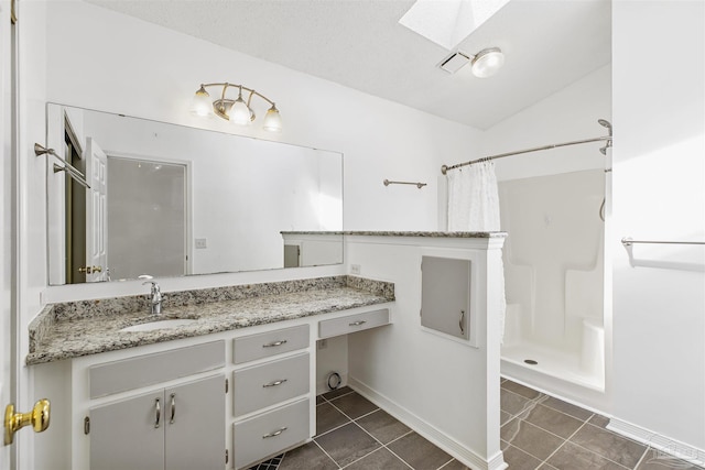 bathroom featuring tile patterned flooring, vanity, curtained shower, and vaulted ceiling with skylight