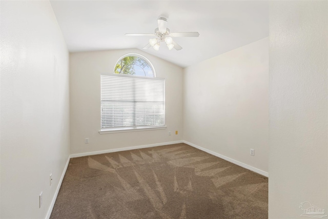 empty room with lofted ceiling, carpet floors, and ceiling fan