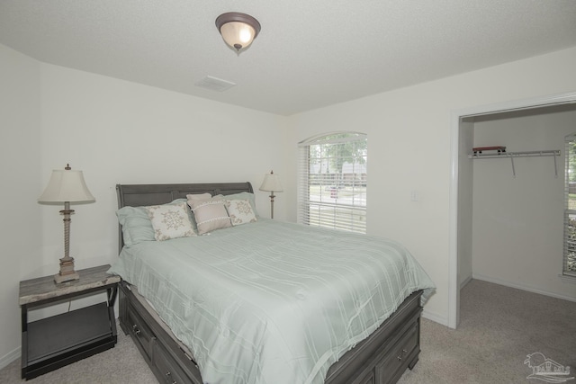 bedroom featuring baseboards, light colored carpet, and visible vents