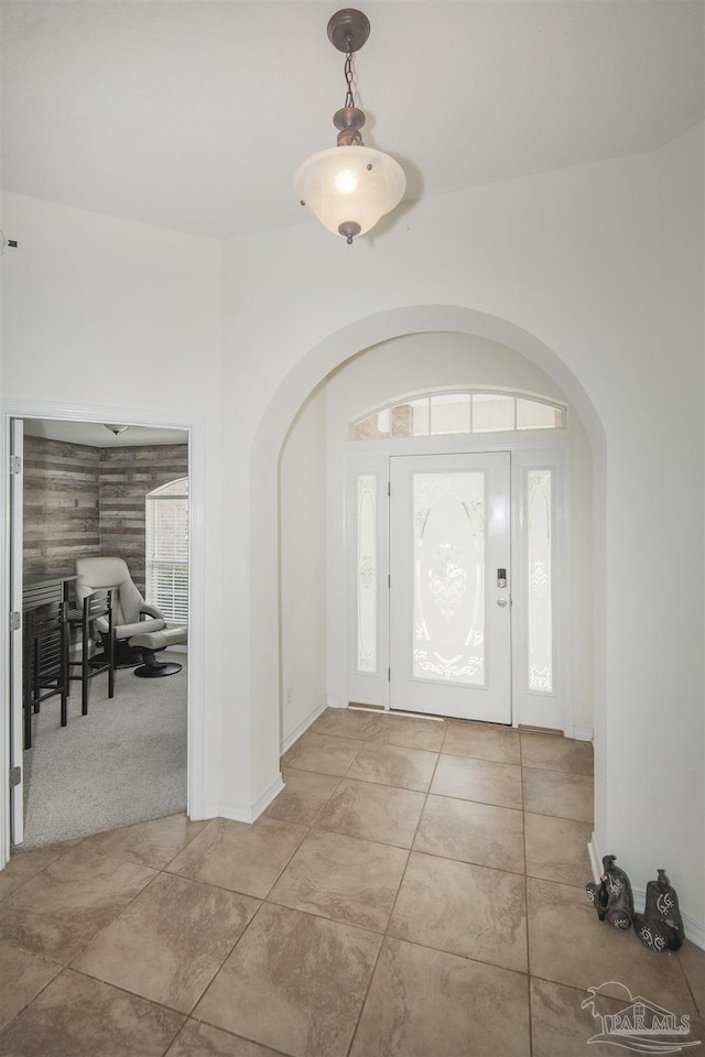 entryway with arched walkways and baseboards