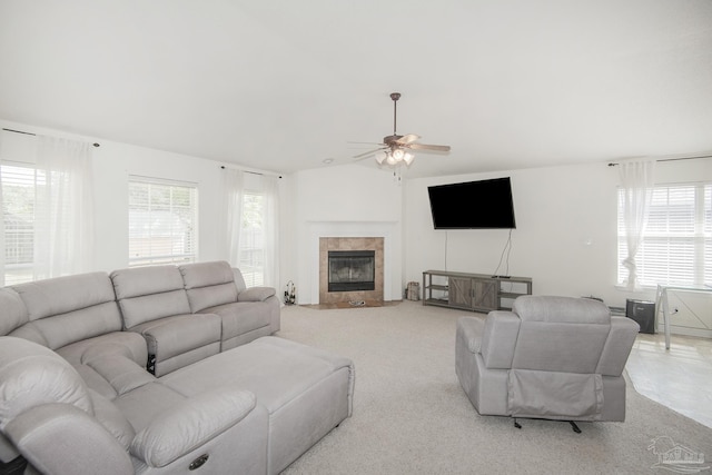 living room featuring ceiling fan, vaulted ceiling, a wealth of natural light, and a tile fireplace