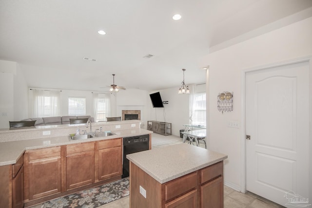 kitchen featuring a ceiling fan, open floor plan, a tile fireplace, a sink, and dishwasher