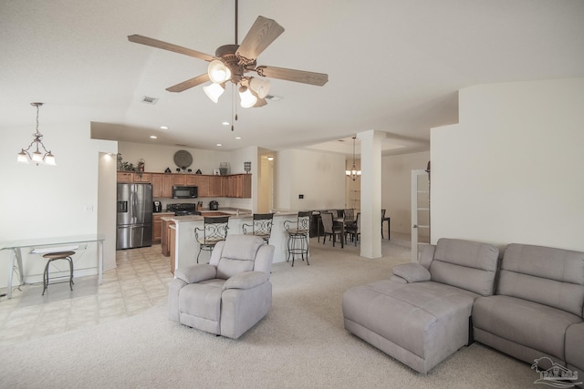 living area featuring visible vents, recessed lighting, ceiling fan with notable chandelier, and light colored carpet
