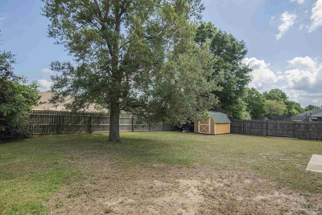 view of yard with a fenced backyard, a shed, and an outbuilding
