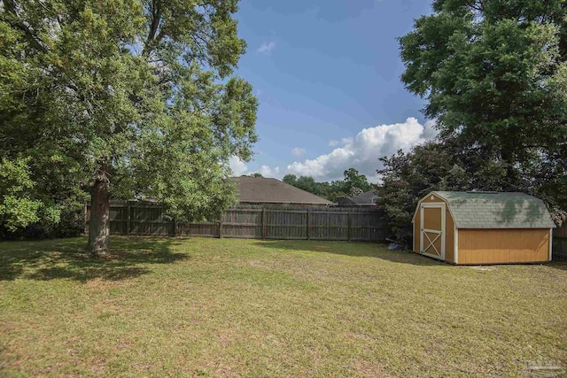 view of yard featuring a fenced backyard, an outbuilding, and a storage shed