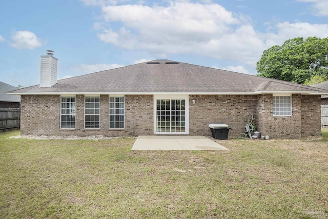back of house featuring a lawn, a patio, a chimney, and roof with shingles