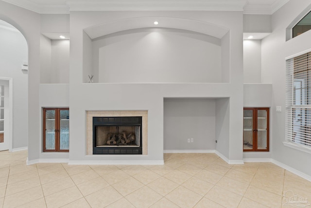 unfurnished living room featuring light tile patterned flooring, crown molding, and a high ceiling