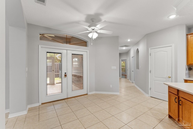 empty room featuring ceiling fan, light tile patterned flooring, french doors, and a textured ceiling