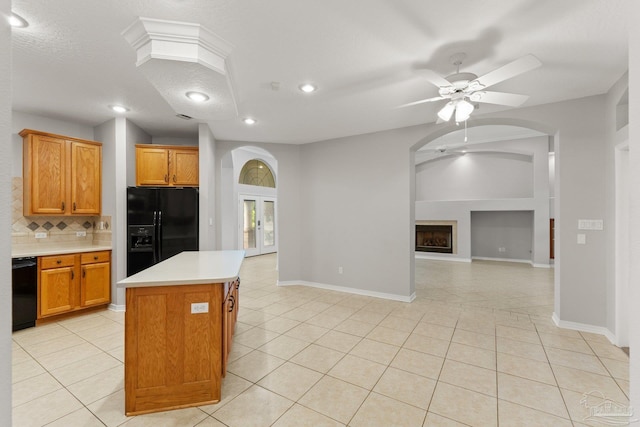 kitchen featuring ceiling fan, a kitchen island, light tile patterned floors, and black appliances