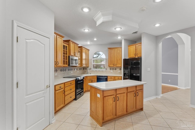 kitchen featuring a textured ceiling, black appliances, a kitchen island, and light tile patterned floors