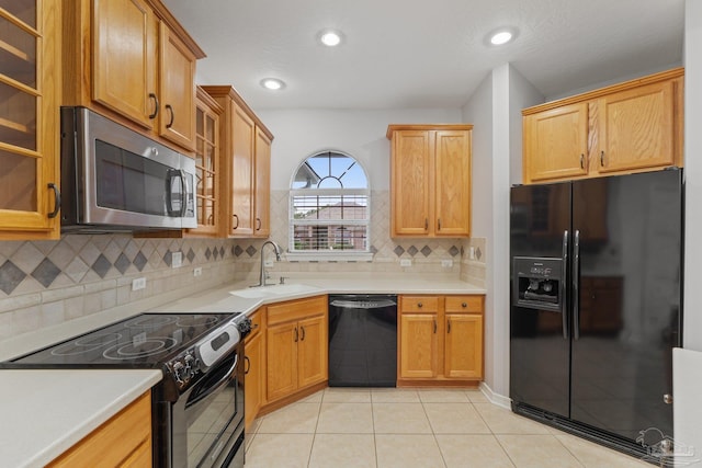 kitchen with light tile patterned floors, sink, a textured ceiling, backsplash, and black appliances