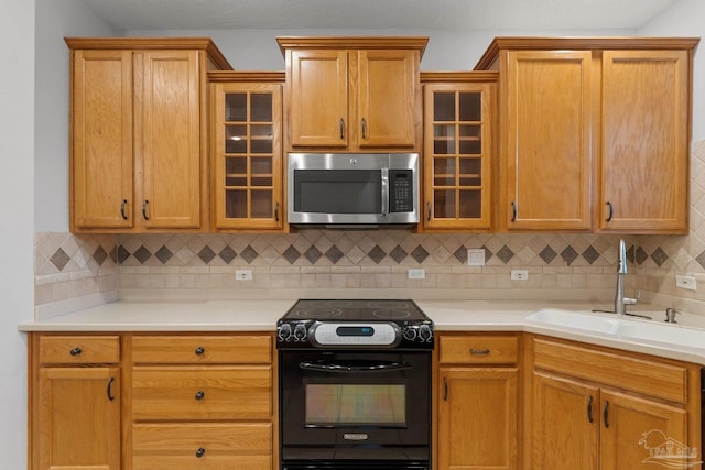 kitchen featuring black electric range, sink, and tasteful backsplash