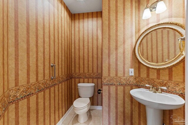 bathroom with toilet and tile patterned floors