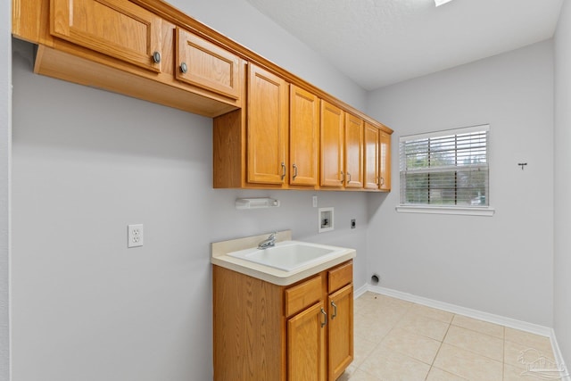 interior space with hookup for a washing machine, light tile patterned flooring, hookup for an electric dryer, cabinets, and sink