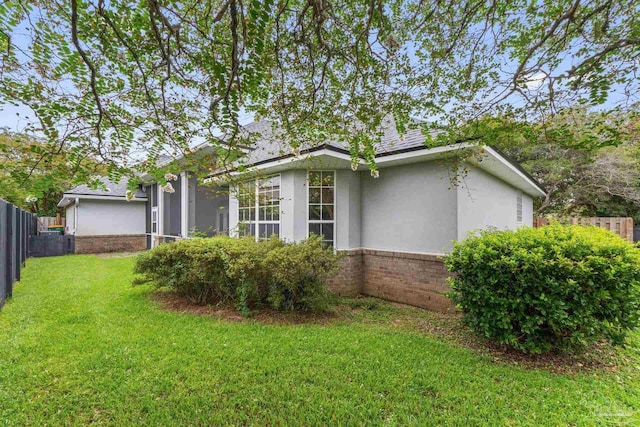 view of side of home with a yard