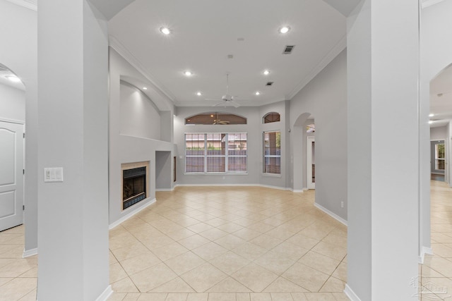 unfurnished living room featuring ceiling fan, crown molding, and light tile patterned floors