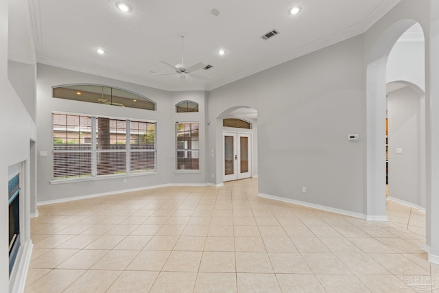 unfurnished living room featuring light tile patterned flooring, ornamental molding, and ceiling fan