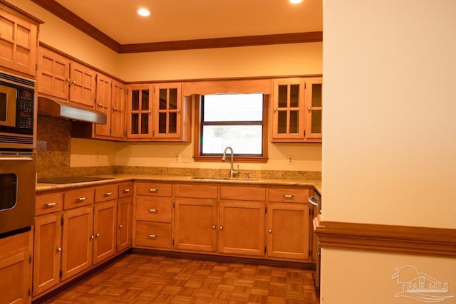 kitchen featuring parquet floors, appliances with stainless steel finishes, crown molding, and sink