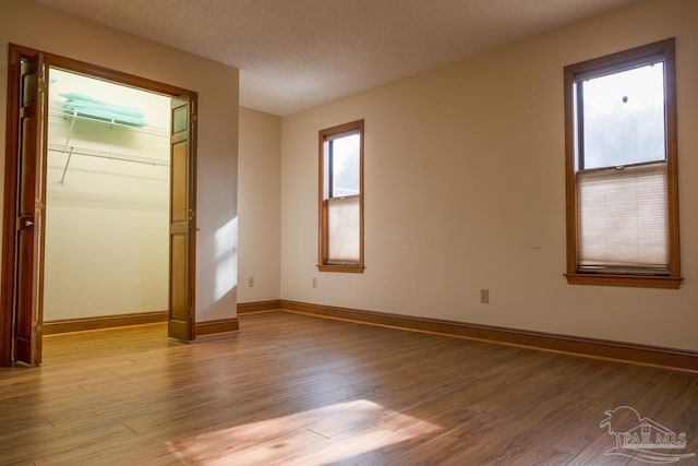 spare room featuring light hardwood / wood-style flooring and a textured ceiling