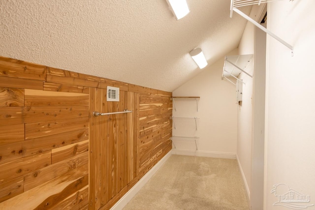 walk in closet featuring light carpet and lofted ceiling