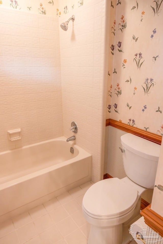 bathroom with tile patterned flooring, toilet, and tiled shower / bath