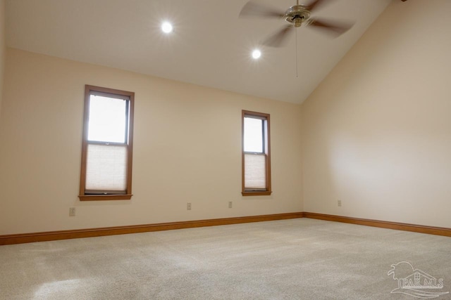 spare room with vaulted ceiling, light colored carpet, and a healthy amount of sunlight