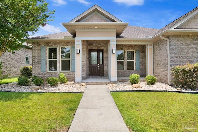 5936 Huntington Creek Blvd, Pensacola, FL 32526 - view of exterior entry featuring brick siding, a yard, covered porch, and a shingled roof