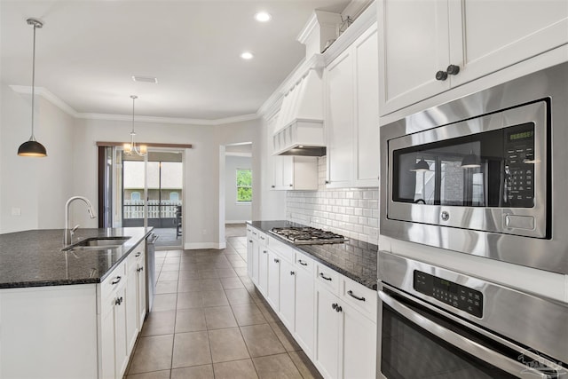 5936 Huntington Creek Blvd, Pensacola, FL 32526 - kitchen featuring appliances with stainless steel finishes, backsplash, white cabinets, dark stone countertops, and ornamental molding