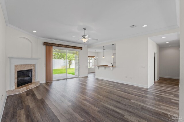 2006 Costa Verde Ct, Navarre, FL 32566 - unfurnished living room with ceiling fan, dark wood-style flooring, a fireplace, baseboards, and crown molding