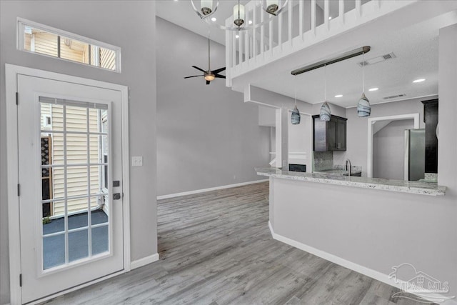 601 E Burgess Rd Unit J2, Pensacola, FL 32504 - kitchen featuring freestanding refrigerator, a towering ceiling, wood finished floors, baseboards, and ceiling fan