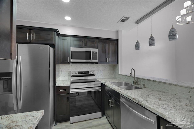 601 E Burgess Rd Unit J2, Pensacola, FL 32504 - kitchen featuring stainless steel appliances, a sink, light stone counters, light wood-style floors, and tasteful backsplash