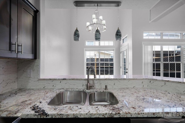 601 E Burgess Rd Unit J2, Pensacola, FL 32504 - kitchen featuring a sink, decorative backsplash, a chandelier, and light stone counters
