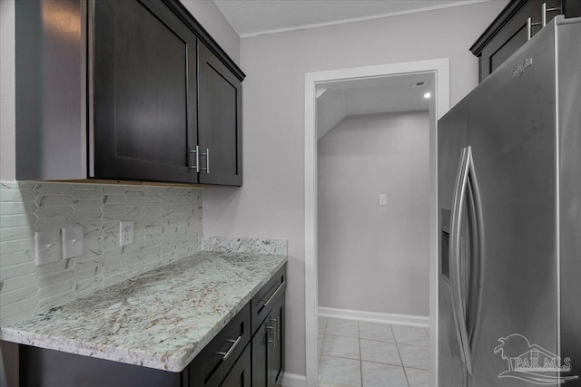 601 E Burgess Rd Unit J2, Pensacola, FL 32504 - kitchen with stainless steel fridge with ice dispenser, tasteful backsplash, baseboards, light stone countertops, and light tile patterned floors