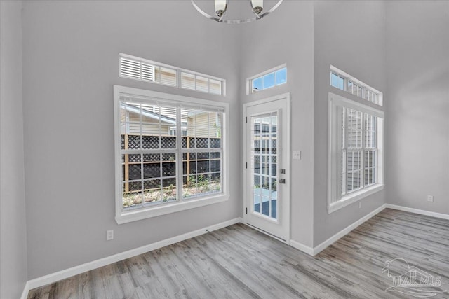 601 E Burgess Rd Unit J2, Pensacola, FL 32504 - interior space with wood finished floors, plenty of natural light, baseboards, a chandelier, and a towering ceiling