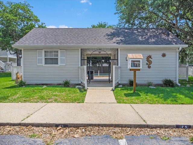 601 E Burgess Rd Unit J2, Pensacola, FL 32504 - view of front facade featuring a porch, a front lawn, and a shingled roof