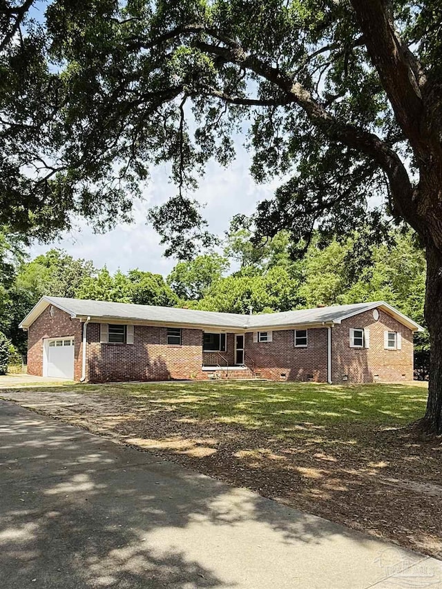 single story home featuring brick siding, an attached garage, and aphalt driveway