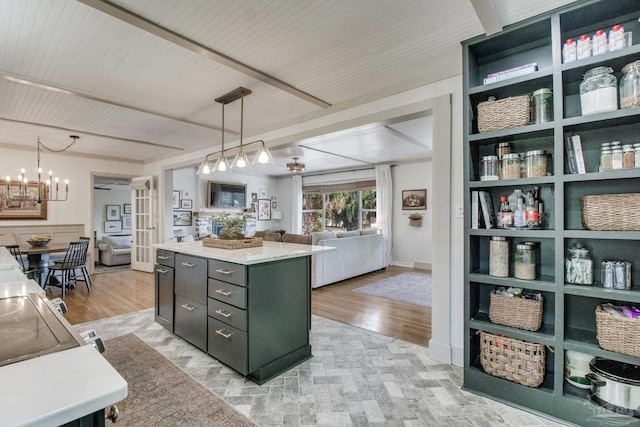 kitchen with a kitchen island, light countertops, light wood-style floors, decorative light fixtures, and open floor plan