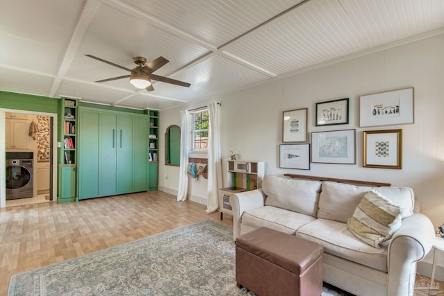 living room with washer / dryer, a ceiling fan, and light wood finished floors