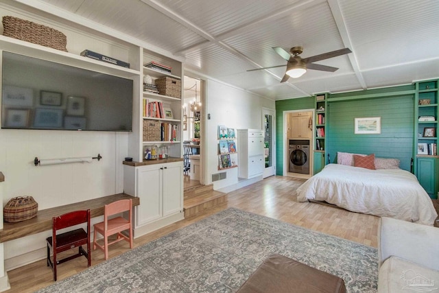 bedroom featuring washer / dryer, ceiling fan with notable chandelier, and light wood-type flooring