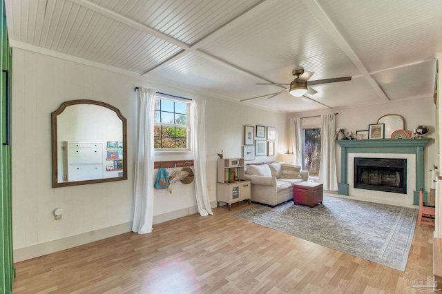 living room with a ceiling fan, a fireplace with flush hearth, wood finished floors, and baseboards